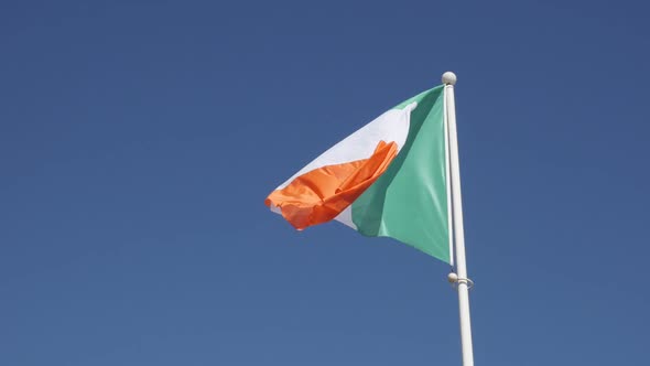 Slow motion tricolour striped shiny  Ireland flag against blue sky on wind 1920X1080 HD footage - Or alt