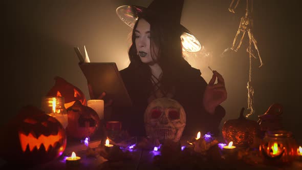 Young Witch Is Reading the Book Aloud and Laughs Holding Aroma Stick alt