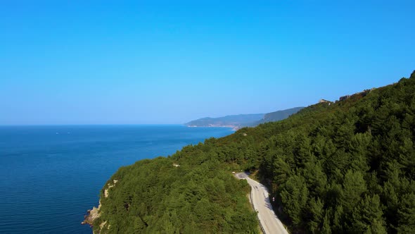 steep green mountains, deep forest and mountain road, beautiful valley and blue sea alt