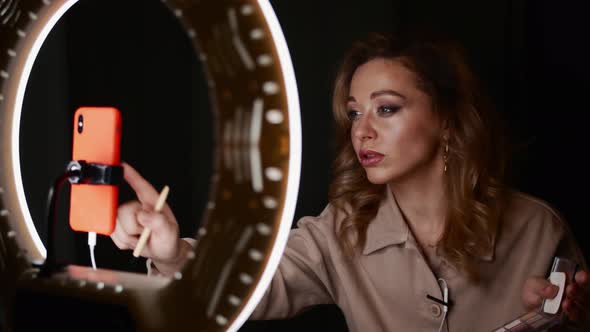 Makeup Artist Young Pretty Woman Uses Smartphone Connected to Ring Light
