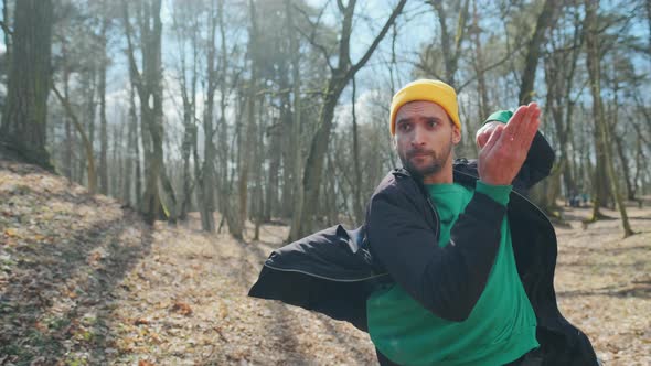 Professional Young Dancer in a Yellow Hat Is Dancing in the Wood. Nice Hipster Guy Outdoors. alt