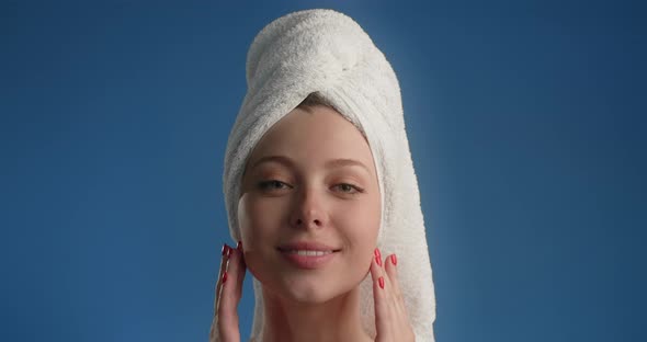 Portrait of Pretty Woman with Towel on Her Head Applying Face Care By Fingers in Slow Motion