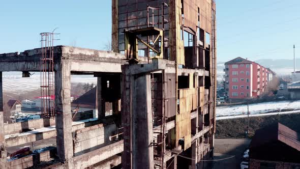 Ruins Of An Abandoned Old Industrial Warehouse Building On A Sunny Winter Day. ascending shot alt