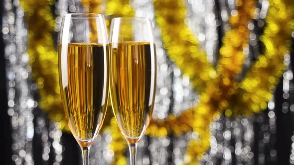 Two Glasses of Champagne Rotating with Christmas Silver and Gold Tinsel