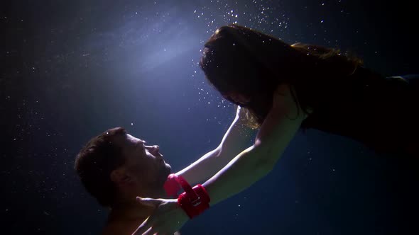 Embrace of Lovers Underwater Man and Woman are Swimming in Pool and Embracing alt