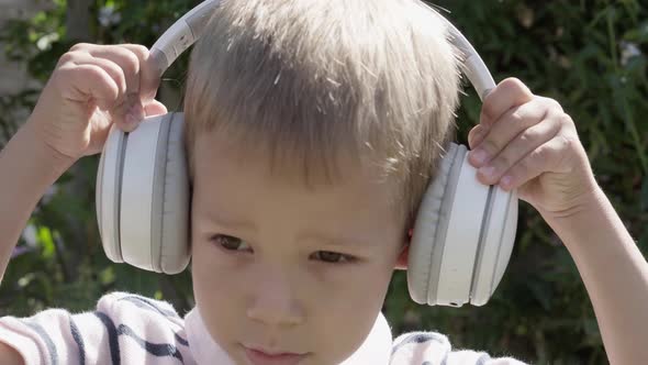 Portrait of Cute Little Boy With Headphones Listening to Music