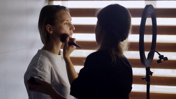 Pretty Actress Waits for Stylist to Apply Elegant Makeup