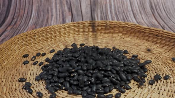 Brown bowl full of dry black beans. Healthy eating and vegetarian concept.