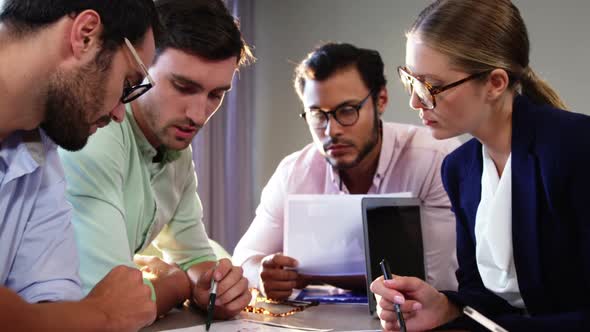 Businesspeople interacting over a document alt