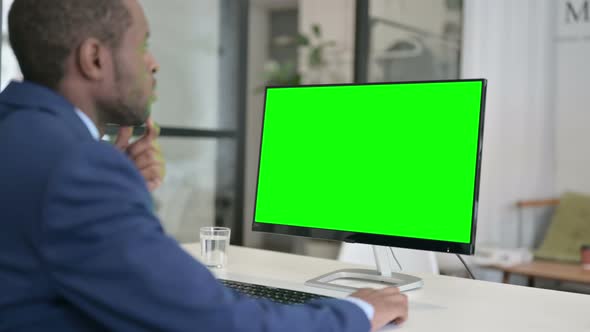 African Businessman Using Desktop with Green Chroma Key Screen alt