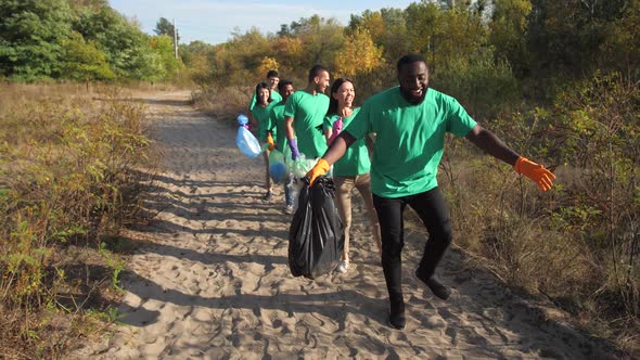 Happy Diverse Volunteers Dancing Collecting Trash alt