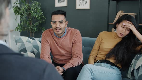 Middle Eastern Man and Asian Woman Fighting During Family Therapy Session in Office alt