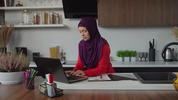 Lovely Independent Muslim Female in Hijab Networking Online on Laptop Pc at Home alt