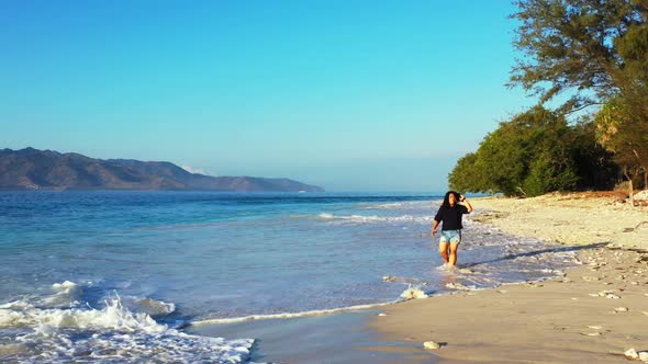 Female model tans on tranquil resort beach lifestyle by turquoise water with clean sand background o alt