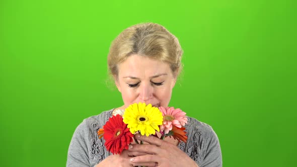 Woman Is Sniffing Flowers. Green Screen alt