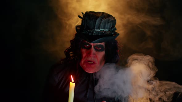 Frightening Creepy Senior Man with Halloween Witcher Makeup Looking at Candle Conjure Hex Wiz alt