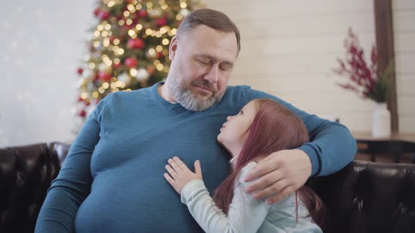 Portrait of Happy Mid-adult Father Hugging Little Cute Daughter and Talking. Cheerful Caucasian Man alt