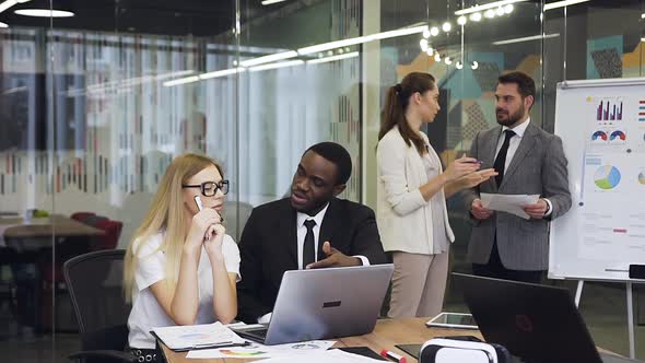 Male and Female Business People which Working Under Joint Project in Boardroom alt