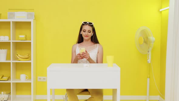 Cheerful Woman In Wireless Headphones Is Using Mobile Phone alt