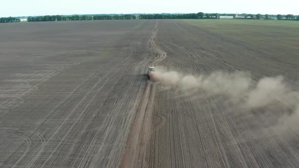 Drone Shot of Tractor Driving Across Field alt