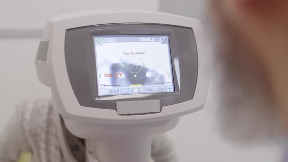 Optometrist Checking Eyes of Child with Autorefractor alt