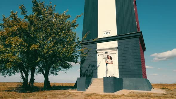 Happy Couple in Love Standing Near a Small Building in the Field alt