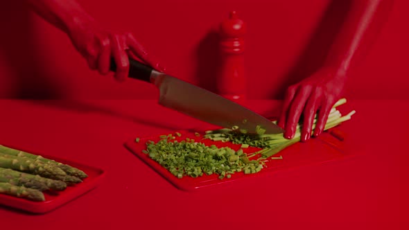 Wide Shot of Beautiful Red Woman Hands Cutting Leeks with Knife on Board alt