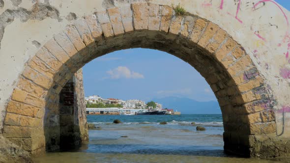 Stone Bridge Through Mediterranean Sea with Cityscape on Background. Travel Background. Special