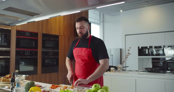 Man Blogger in Modern Kitchen Chopping Fresh Green Vegetables Recording Food Recipe alt