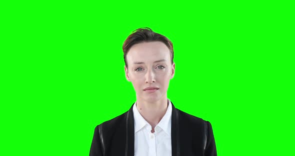 Sad Caucasian woman looking at camera on green background