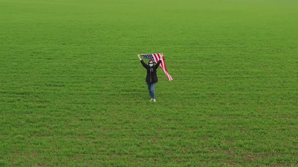 Woman in a Medical Mask with Usa Flag in the Field