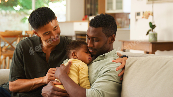 Same Sex Male Couple Bonding at Home With Infant During Daytime  