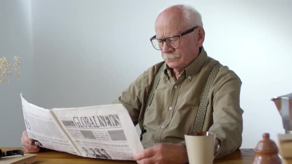 Elderly Man with Newspaper Smiling for Camera alt