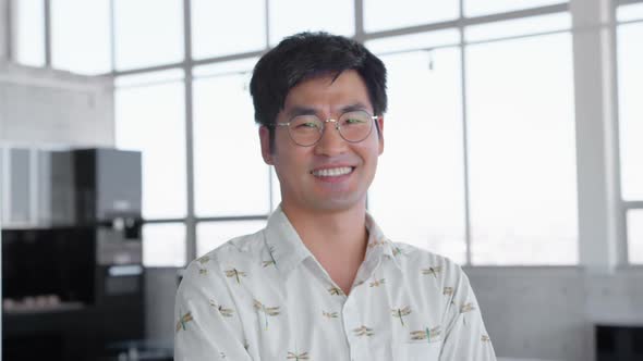 Asian male executive standing with arms crossed in modern office 4k alt