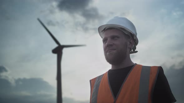 PORTRAIT Young Man with a Beard in a White Protective Helmet and a Vest Shows Like Thumb Up Approves alt