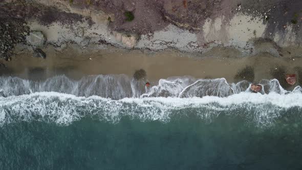 Aerial View From Above on Old Rusty Floating Marine Mine on the Beach and Volcanic Rocky Shores alt