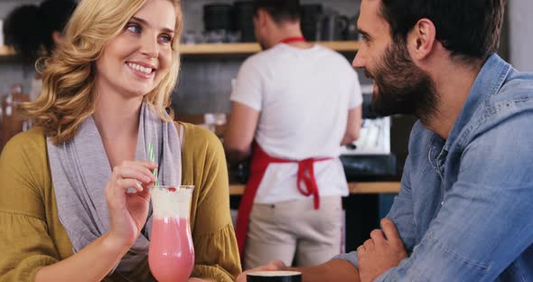 Couple interacting while having a cup of coffee and milkshake alt