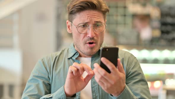 Portrait of Upset Middle Aged Man Having Loss on Smartphone  alt