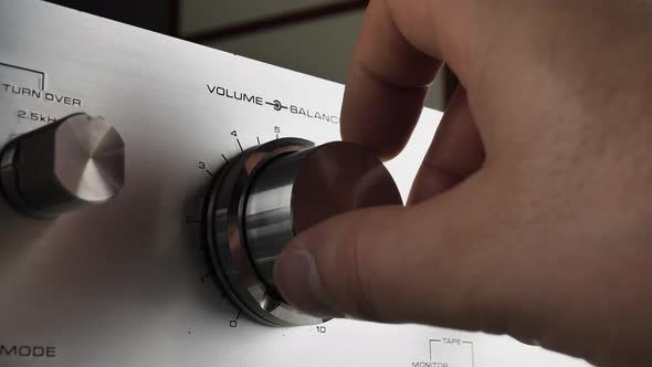 The Hand Controls the Volume of the Radio and Switches Various FM Stations on the Shiny Gray Panel alt
