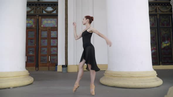 Side View of Elegant Slim Ballerina Walking on Tiptoes with Columns Passing at Front alt