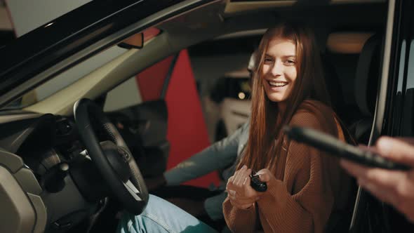 Car Dealer Giving Key to New Car Owner alt