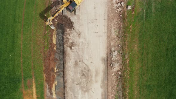 Aerial View of Excavator Collects Soil From the Green Field alt