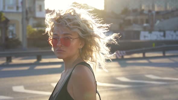 Curly hair woman posing against the sunlights.