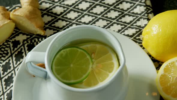 Lemon tea in a jug with lemon 4k alt