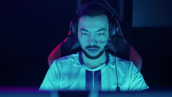 Portrait of a Focused Gamer Plays a Video Game Cyber Sportsman at the Championship Blue Neon Light alt
