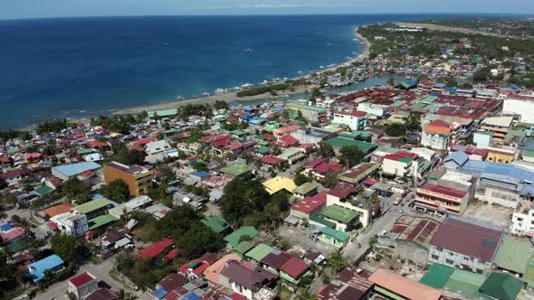 Aerial view drone footage of houses with shoreline and blue sea during daytime in HD quality. alt