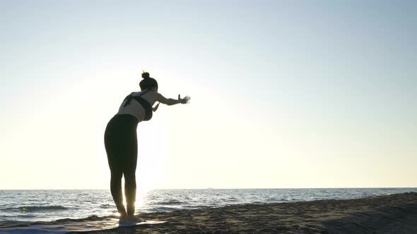 Young Caucasian Woman Practicing Yoga on the Beach Near Calm Sea.