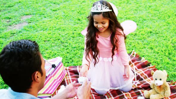 Father and daughter having toy tea party alt
