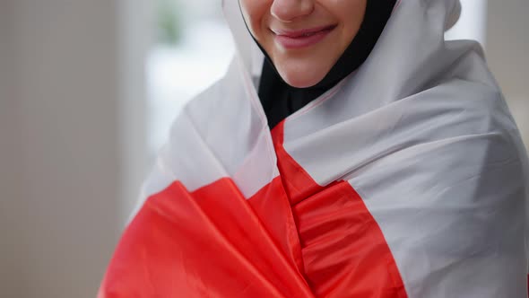 Unrecognizable Young Woman in Hijab Wrapping in Canadian Flag Smiling alt