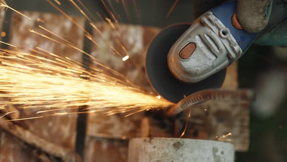 Man Works With Circular Saw Cuts Rebar Metal Tube